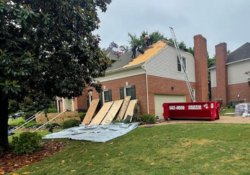 Professional roofers replacing an old roof with new, high-quality shingles on a suburban home in Brentwood, TN, showcasing skilled workmanship and attention to detail in roof installation.